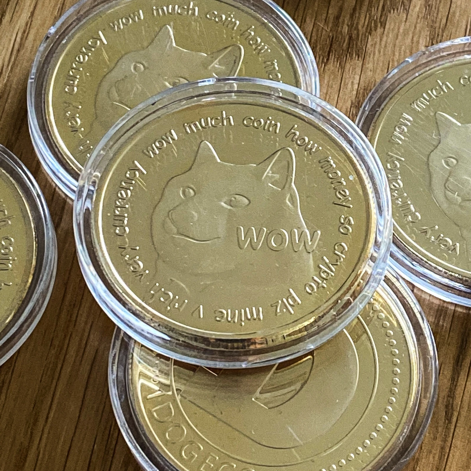 Gold Dogecoin collectible coins in protective capsules on a wooden surface